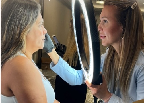 Elena Kaligina evaluating work under a ring light at a PMU championship